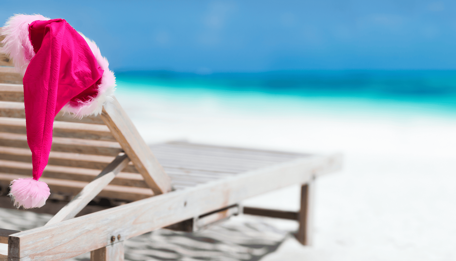 Cappellino di Babbo Natale appoggiato sul lettino in spiaggia